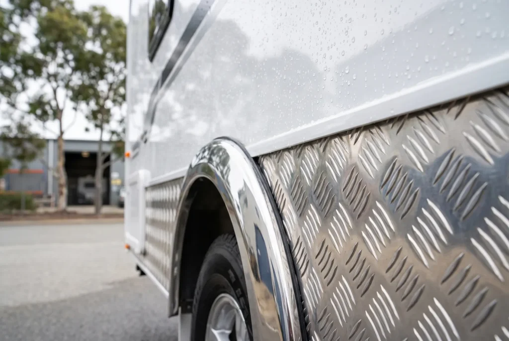 Caravan exterior detailing in O'Connor showing polished aluminium checker-plate and spotless chrome wheel arch